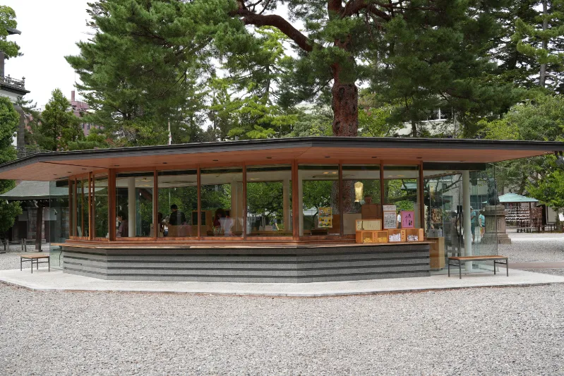 モダンなガラス張りのお守り売店。様々なお守りが並んでいます